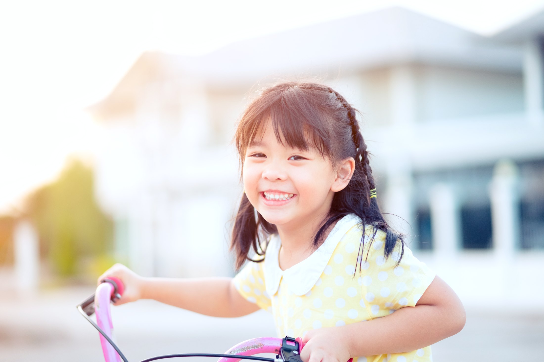 A smiling girl riding her bike