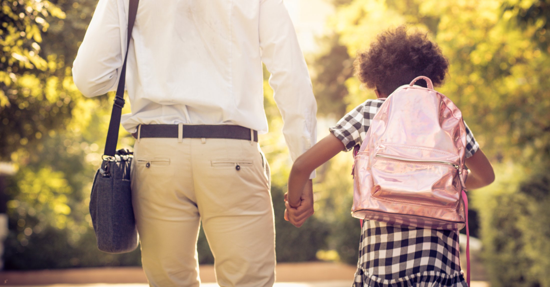 A parent and child walking hand in hand